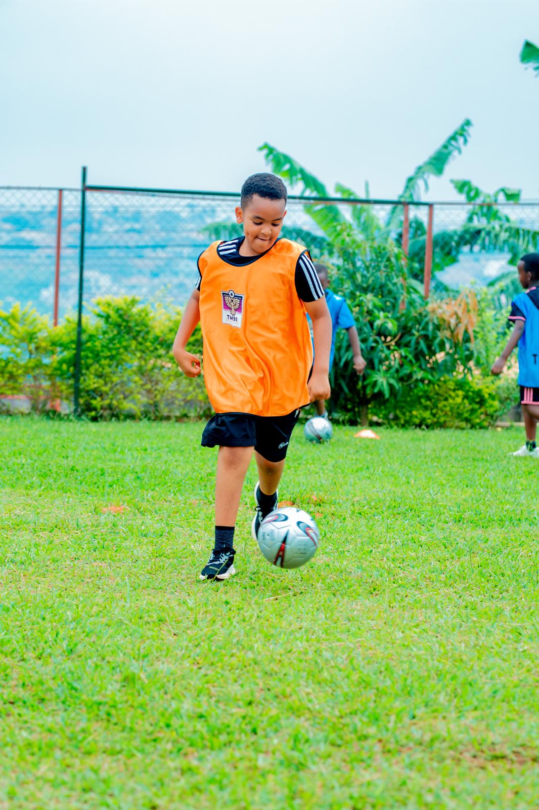 A TM9R academy player on the ball in Kigali